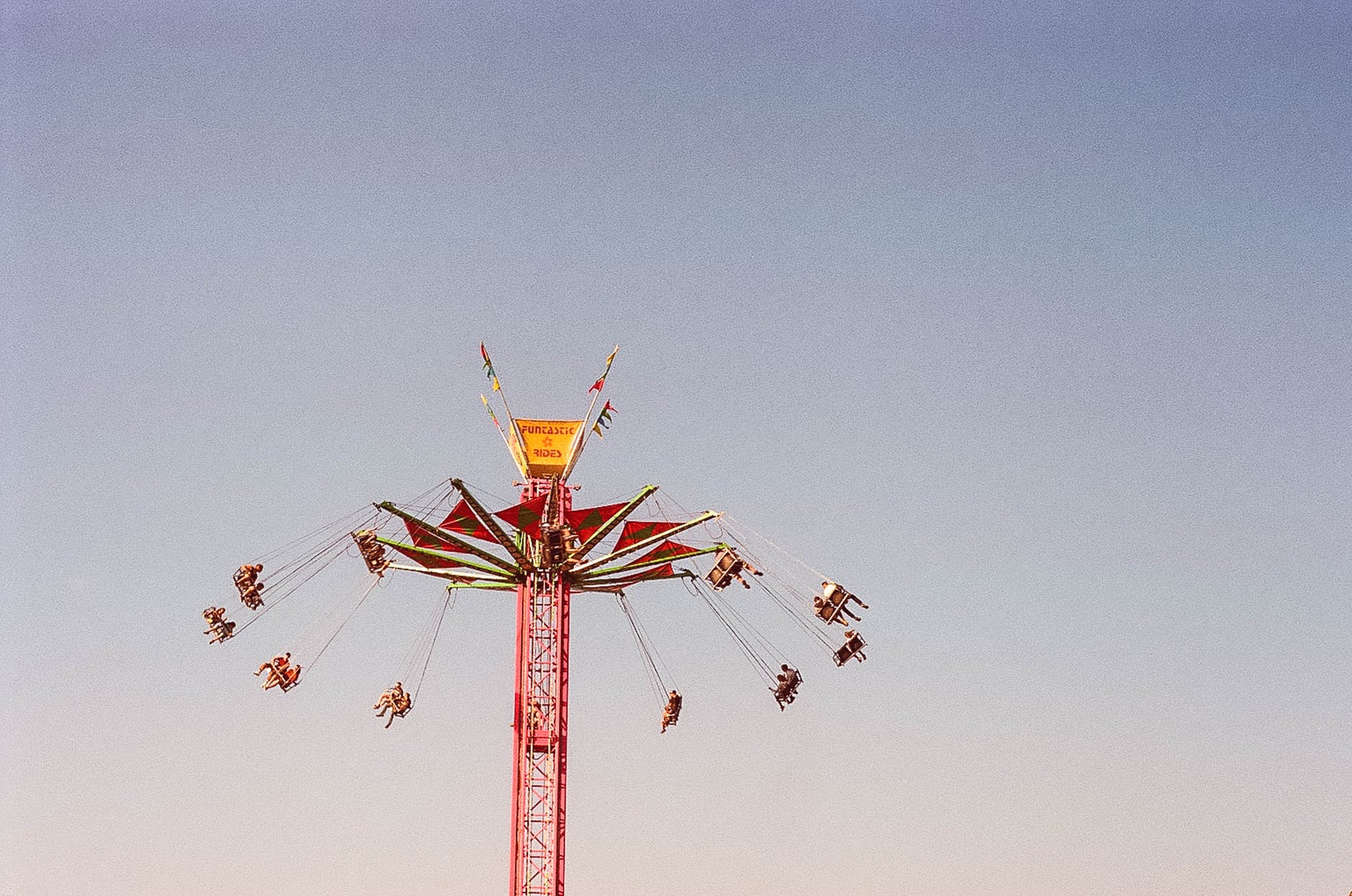people riding on swing rides under gray sky