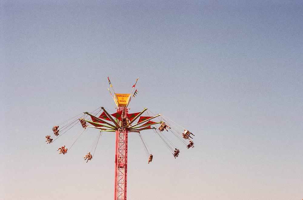people riding on swing rides under gray sky